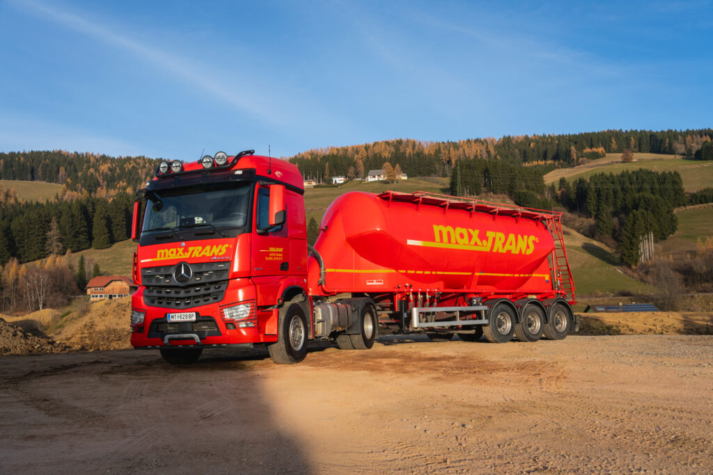 Sie sehen einen Silo Sattelzug von maxTRANS. Wir bieten flexible und zuverlässige Transportlösungen für Schüttgut, Asphalt sowie voluminöse und pulverförmige Güter inklusive Hebearbeiten – effizient und verlässlich umgesetzt durch einen modernen Fuhrpark und qualifizierte Fahrer.