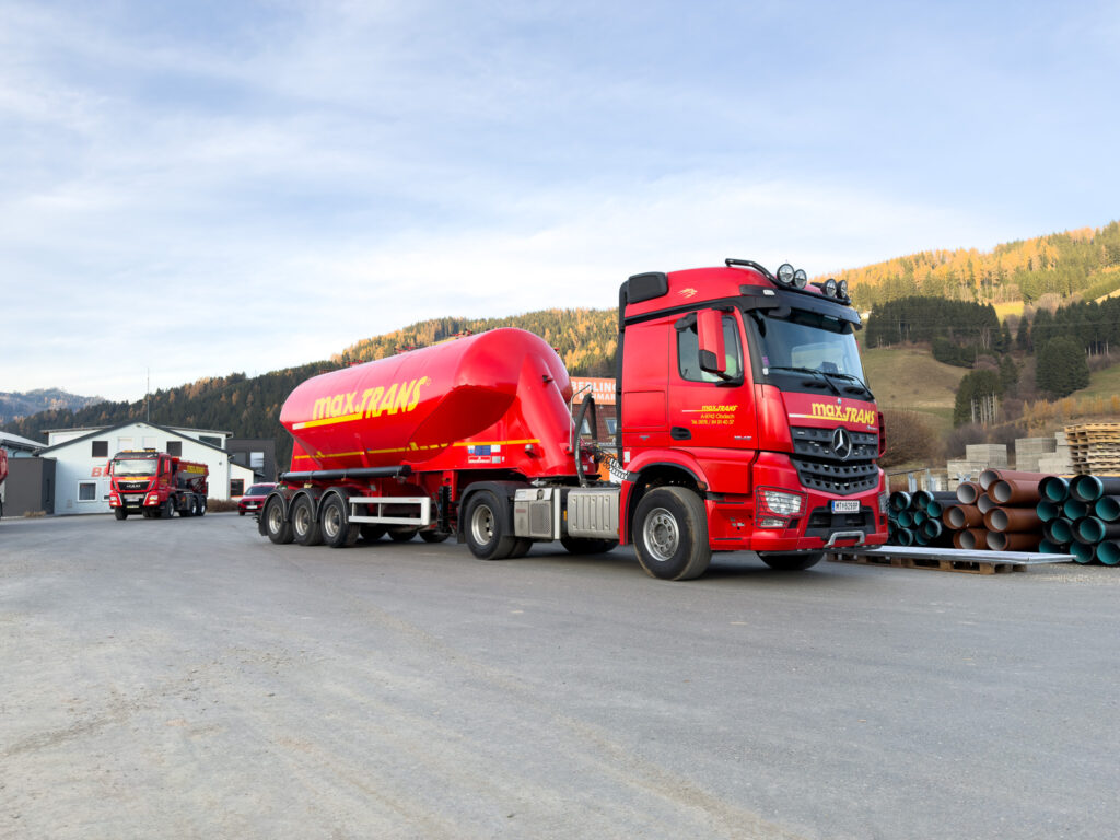 Sie sehen einen Silo Sattelzug von maxTRANS. Wir bieten flexible und zuverlässige Transportlösungen für Schüttgut, Asphalt sowie voluminöse und pulverförmige Güter inklusive Hebearbeiten – effizient und verlässlich umgesetzt durch einen modernen Fuhrpark und qualifizierte Fahrer.